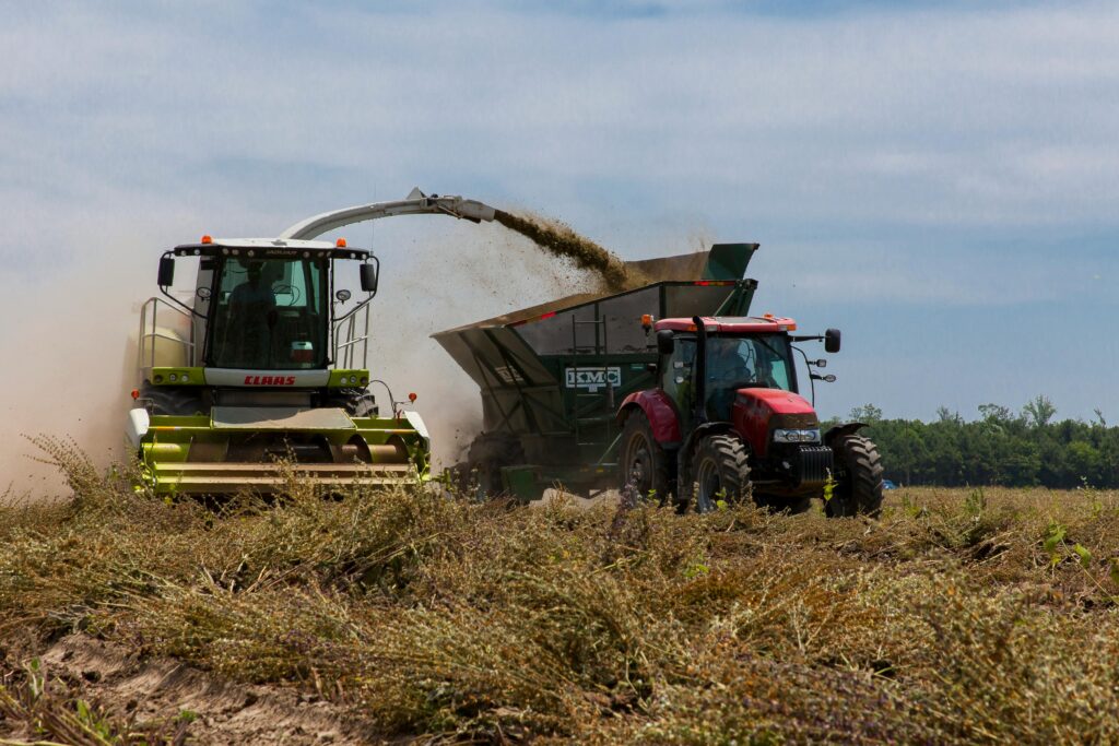 Tractors working in a field during harvest in rural North Carolina on a clear day.
