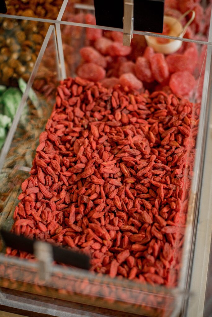An assortment of goji berries and other dried fruits in a market container.